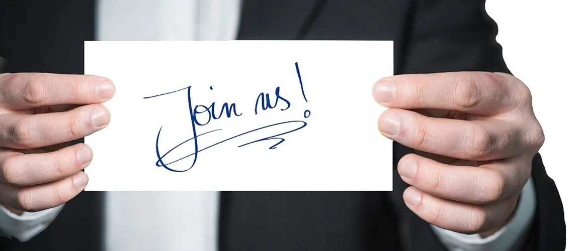 Person holding a letter with the sentence "Join us!"